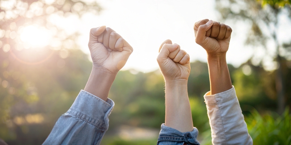 כוחה של קבוצה - 3 ידיים של אנשים מונפות באויר בניצחון